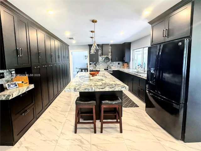 14870 SW 152nd Ct, Miami, FL 33196 - kitchen with black fridge with ice dispenser, light marble finish floors, backsplash, wall chimney exhaust hood, and recessed lighting