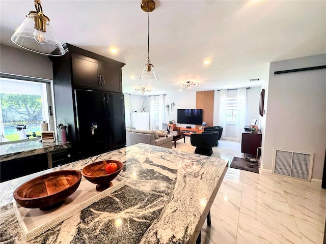 14870 SW 152nd Ct, Miami, FL 33196 - kitchen with light marble finish floors, hanging light fixtures, plenty of natural light, and light stone countertops
