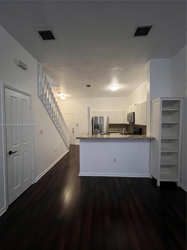 20820 San Simeon Way Unit 24-G, Miami, FL 33179 - kitchen featuring stainless steel appliances, dark wood-type flooring, white cabinetry, a peninsula, and baseboards