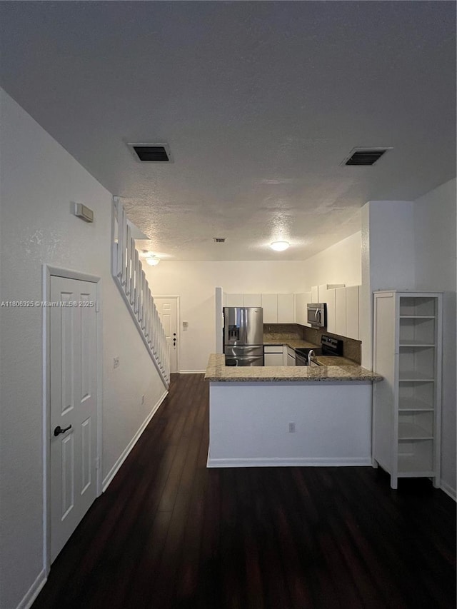 20820 San Simeon Way Unit 24-G, Miami, FL 33179 - kitchen featuring appliances with stainless steel finishes, dark wood-style floors, a peninsula, white cabinets, and baseboards