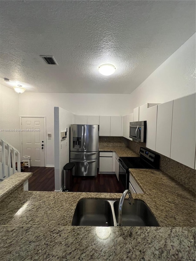20820 San Simeon Way Unit 24-G, Miami, FL 33179 - kitchen with stainless steel appliances, a sink, a textured ceiling, dark wood-style floors, and white cabinets