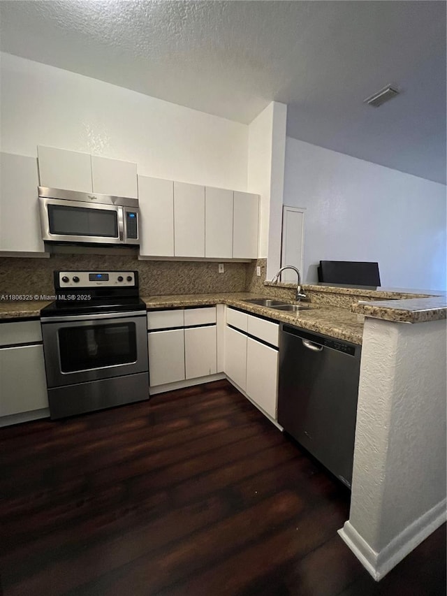 20820 San Simeon Way Unit 24-G, Miami, FL 33179 - kitchen with stainless steel appliances, a sink, dark wood-style floors, tasteful backsplash, and white cabinetry