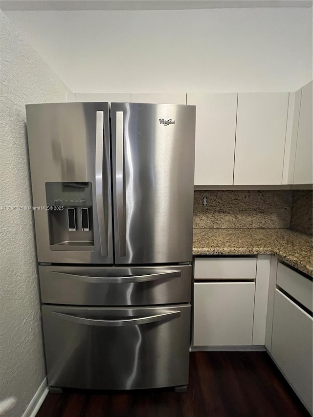 20820 San Simeon Way Unit 24-G, Miami, FL 33179 - kitchen with stainless steel fridge with ice dispenser, dark wood-type flooring, white cabinetry, dark stone countertops, and a textured wall