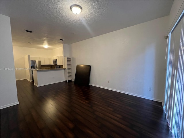20820 San Simeon Way Unit 24-G, Miami, FL 33179 - unfurnished living room featuring dark wood finished floors, baseboards, and a textured ceiling