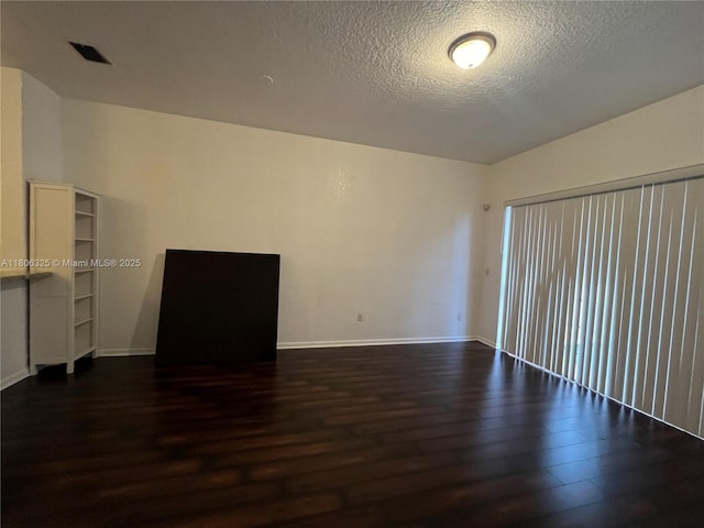 20820 San Simeon Way Unit 24-G, Miami, FL 33179 - empty room featuring dark wood-style floors, a textured ceiling, and baseboards