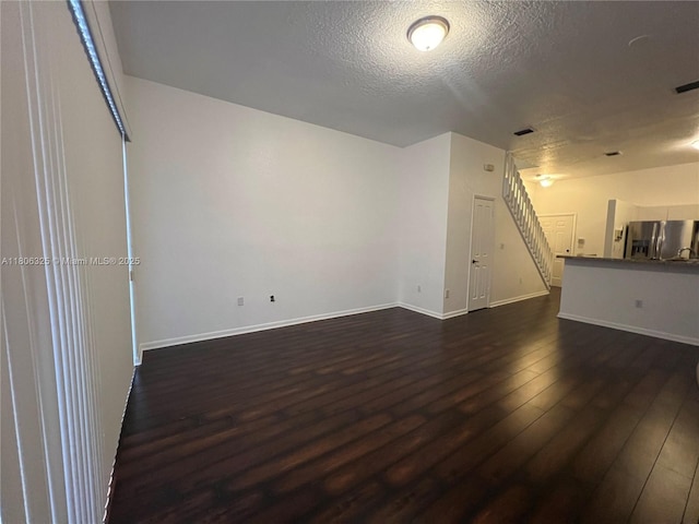 20820 San Simeon Way Unit 24-G, Miami, FL 33179 - unfurnished living room with stairs, dark wood-type flooring, a textured ceiling, and baseboards
