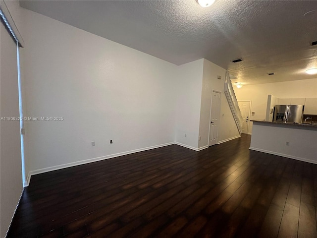 20820 San Simeon Way Unit 24-G, Miami, FL 33179 - unfurnished living room with dark wood-style floors, baseboards, a textured ceiling, and a sink