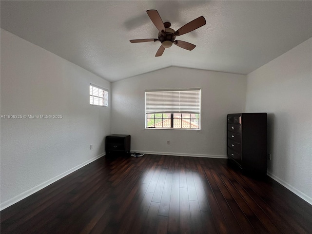 20820 San Simeon Way Unit 24-G, Miami, FL 33179 - unfurnished bedroom with dark wood finished floors, vaulted ceiling, a ceiling fan, and baseboards
