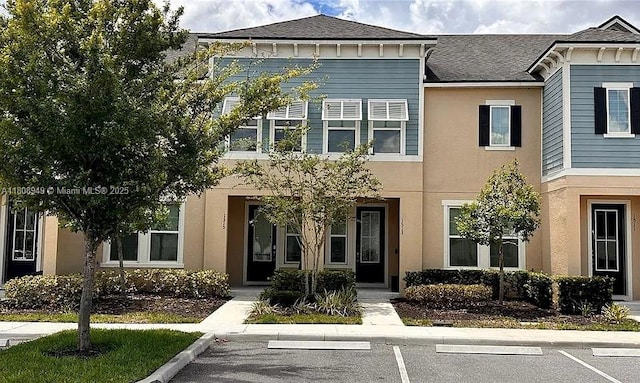 1515 Carey Palm Cir, Kissimmee, FL 34747 - view of front facade with uncovered parking, a shingled roof, and stucco siding