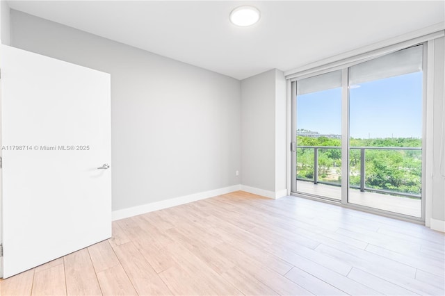 16385 Biscayne Blvd Unit 404, North Miami Beach, FL 33160 - empty room with baseboards, light wood-type flooring, and expansive windows
