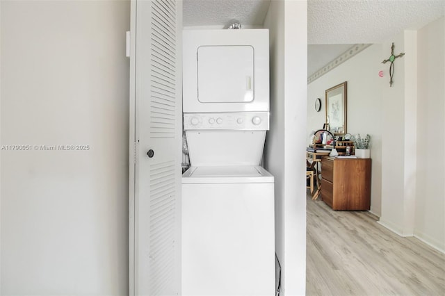 1400 SW 137th Ave Unit 311F, Pembroke Pines, FL 33027 - washroom with stacked washer / drying machine, light wood-type flooring, a textured ceiling, and baseboards