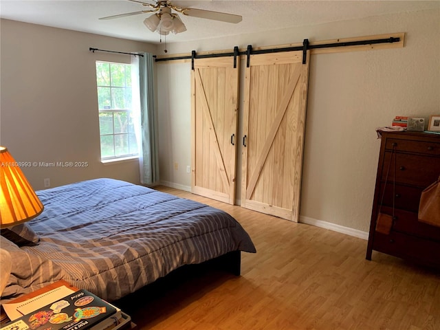 325 E Plymouth, Deland, FL 32724 - bedroom featuring light wood-style floors, a barn door, baseboards, and ceiling fan