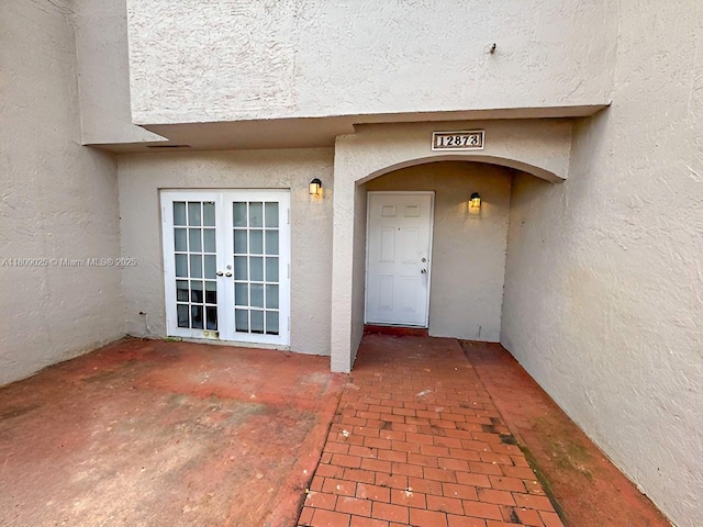 12873 SW 65th Ter, Miami, FL 33183 - view of exterior entry with french doors, stucco siding, and a patio area
