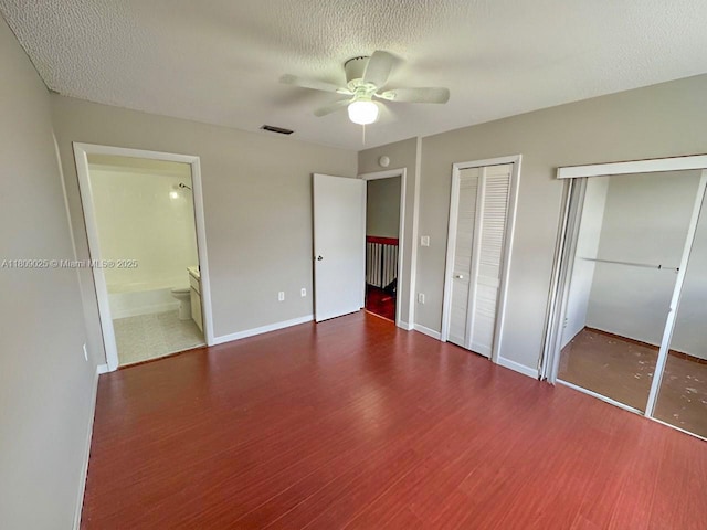 12873 SW 65th Ter, Miami, FL 33183 - unfurnished bedroom featuring multiple closets, wood finished floors, baseboards, ceiling fan, and a textured ceiling