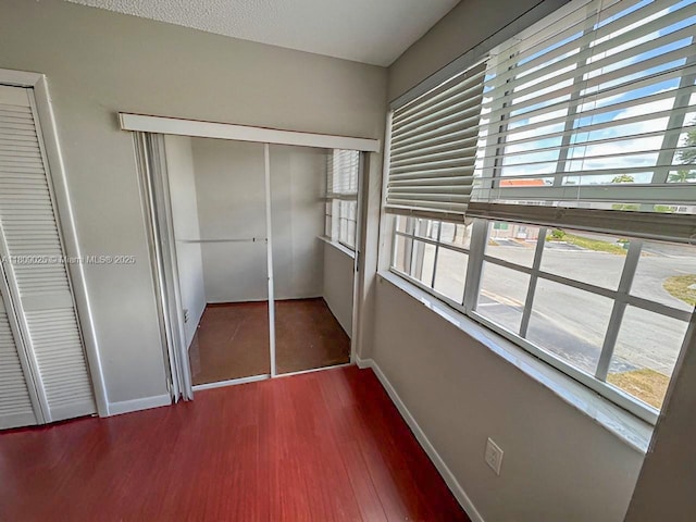 12873 SW 65th Ter, Miami, FL 33183 - unfurnished bedroom with baseboards, multiple windows, wood finished floors, and a closet