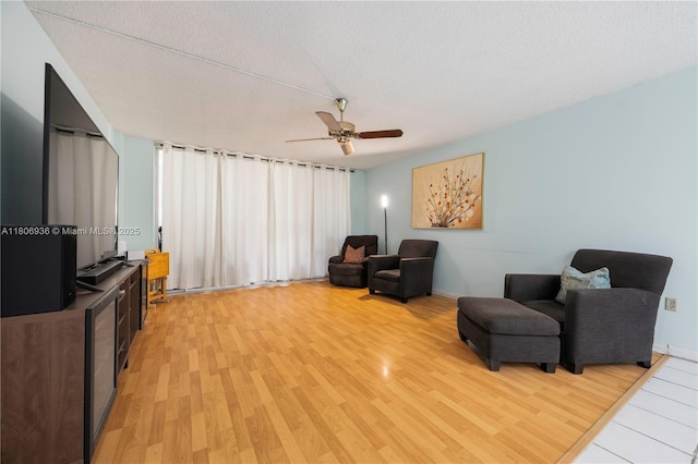 6821 SW 147th Ave Unit 1F, Miami, FL 33193 - sitting room with light wood finished floors, a ceiling fan, a textured ceiling, and baseboards