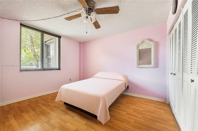 6821 SW 147th Ave Unit 1F, Miami, FL 33193 - bedroom with a closet, light wood-style flooring, baseboards, and a textured ceiling