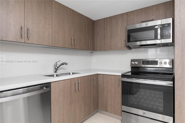 1901 Brickell Ave Unit B1903, Miami, FL 33129 - kitchen featuring appliances with stainless steel finishes, a sink, light countertops, and light tile patterned floors