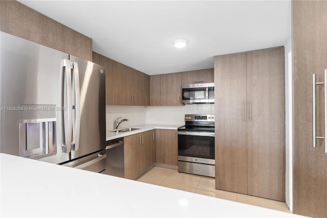 1901 Brickell Ave Unit B1903, Miami, FL 33129 - kitchen with stainless steel appliances, a sink, light countertops, light tile patterned floors, and brown cabinets