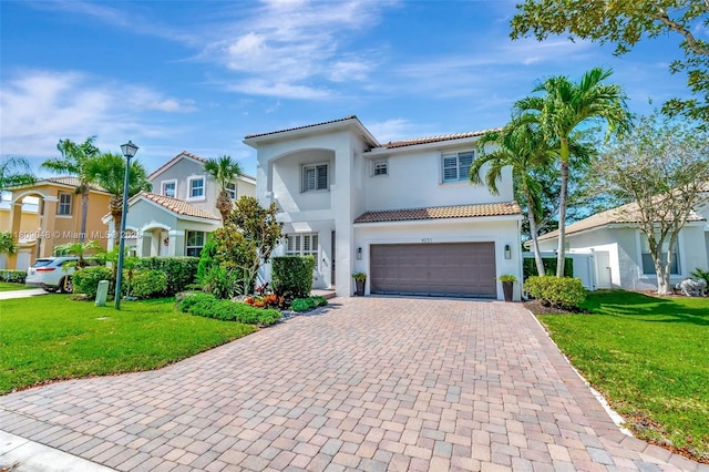 4231 N Magnolia Cir, Delray Beach, FL 33445 - mediterranean / spanish-style house with an attached garage, stucco siding, decorative driveway, a tile roof, and a front lawn