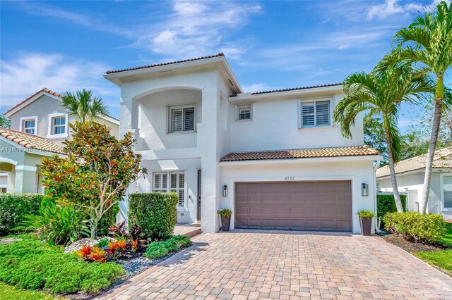 4231 N Magnolia Cir, Delray Beach, FL 33445 - mediterranean / spanish house with stucco siding, an attached garage, a tiled roof, and decorative driveway