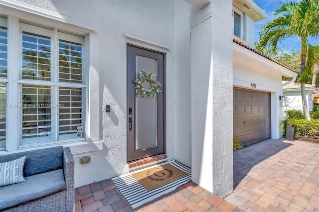 4231 N Magnolia Cir, Delray Beach, FL 33445 - doorway to property with stucco siding and an attached garage