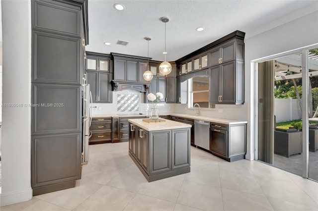 4231 N Magnolia Cir, Delray Beach, FL 33445 - kitchen featuring stainless steel dishwasher, light countertops, refrigerator, tasteful backsplash, and a sink