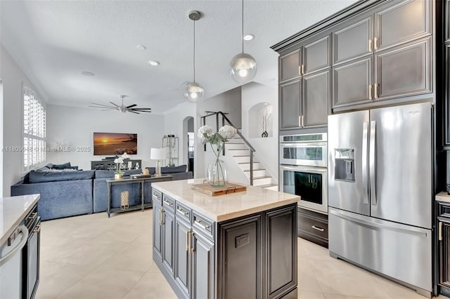 4231 N Magnolia Cir, Delray Beach, FL 33445 - kitchen with appliances with stainless steel finishes, arched walkways, decorative light fixtures, a ceiling fan, and light tile patterned flooring