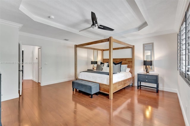 4231 N Magnolia Cir, Delray Beach, FL 33445 - bedroom featuring a tray ceiling, baseboards, wood finished floors, crown molding, and ceiling fan