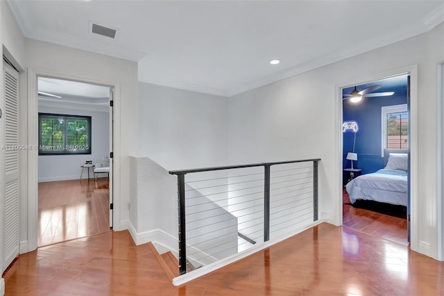 4231 N Magnolia Cir, Delray Beach, FL 33445 - corridor with wood finished floors, ornamental molding, recessed lighting, baseboards, and an upstairs landing