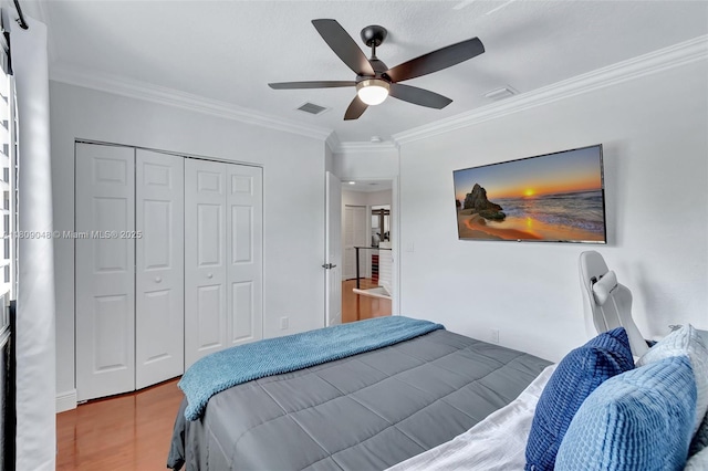 4231 N Magnolia Cir, Delray Beach, FL 33445 - bedroom featuring ornamental molding, a closet, wood finished floors, and a ceiling fan