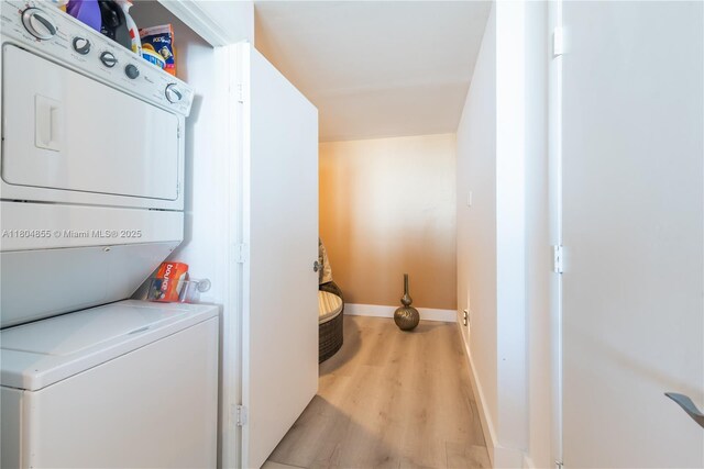 244 Biscayne Blvd Unit 3703, Miami, FL 33132 - laundry area featuring stacked washer and clothes dryer, light wood-type flooring, and baseboards