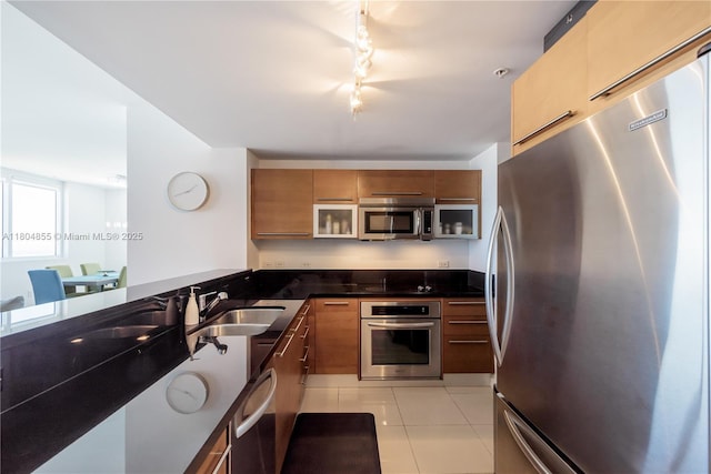 244 Biscayne Blvd Unit 3703, Miami, FL 33132 - kitchen featuring stainless steel appliances, a sink, rail lighting, brown cabinetry, and light tile patterned floors