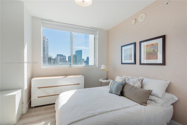 244 Biscayne Blvd Unit 3703, Miami, FL 33132 - bedroom with multiple windows, light wood-style floors, and a city view