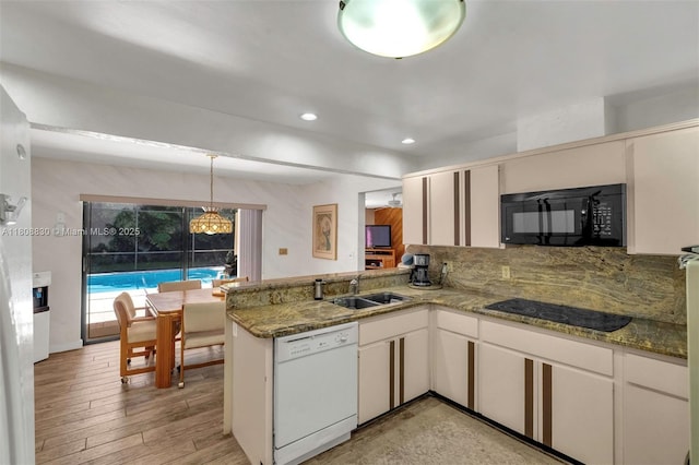 3721 N Park Rd, Hollywood, FL 33021 - kitchen with black appliances, a peninsula, a sink, recessed lighting, and dark stone counters