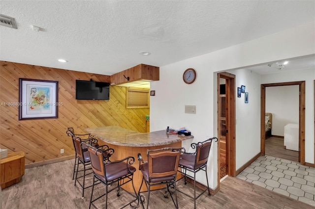 3721 N Park Rd, Hollywood, FL 33021 - dining space with baseboards, wood walls, light wood finished floors, recessed lighting, and a textured ceiling