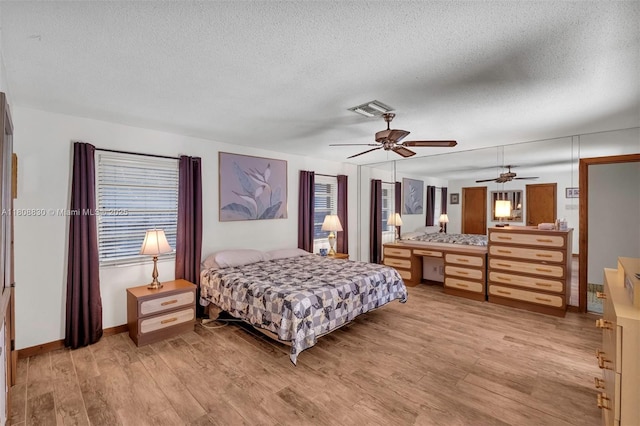 3721 N Park Rd, Hollywood, FL 33021 - bedroom featuring light wood-style floors, multiple windows, a textured ceiling, and baseboards