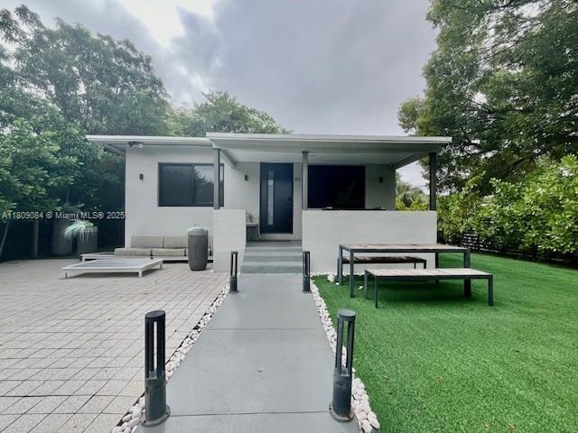 90 NW 33rd St, Miami, FL 33127 - view of front facade featuring a front lawn and stucco siding