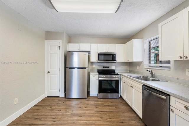 22123 SW 62nd Ct, Boca Raton, FL 33428 - kitchen with appliances with stainless steel finishes, a sink, a textured ceiling, white cabinetry, and light countertops