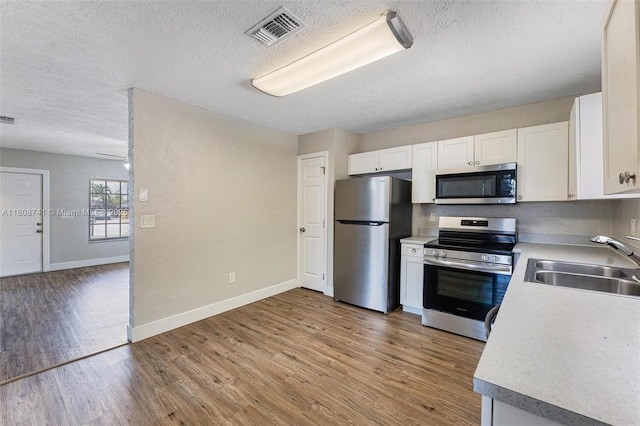 22123 SW 62nd Ct, Boca Raton, FL 33428 - kitchen with appliances with stainless steel finishes, a sink, a textured ceiling, white cabinets, and light countertops