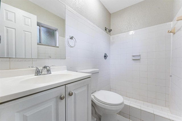 22123 SW 62nd Ct, Boca Raton, FL 33428 - full bathroom featuring a tile shower, vanity, toilet, a textured wall, and tile walls