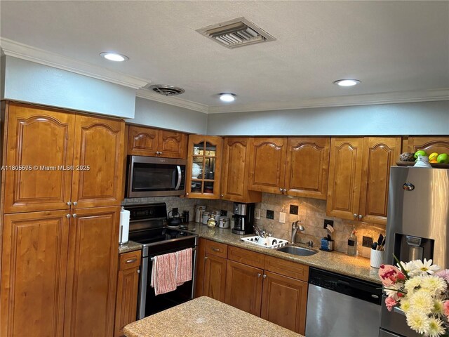 7430 Buchanan St, Hollywood, FL 33024 - kitchen with stainless steel appliances, brown cabinets, backsplash, glass insert cabinets, and ornamental molding