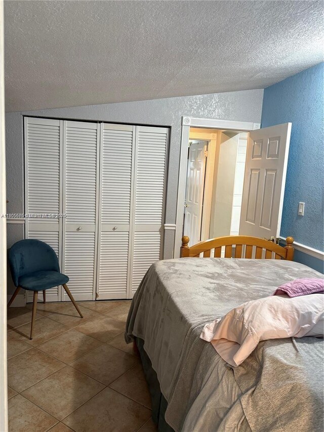 7430 Buchanan St, Hollywood, FL 33024 - bedroom with a textured wall, a textured ceiling, a closet, tile patterned flooring, and lofted ceiling