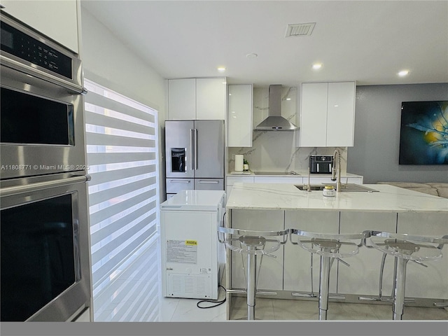 13729 SW 171st Ln, Miami, FL 33177 - kitchen featuring wall chimney range hood, appliances with stainless steel finishes, modern cabinets, a kitchen bar, and recessed lighting