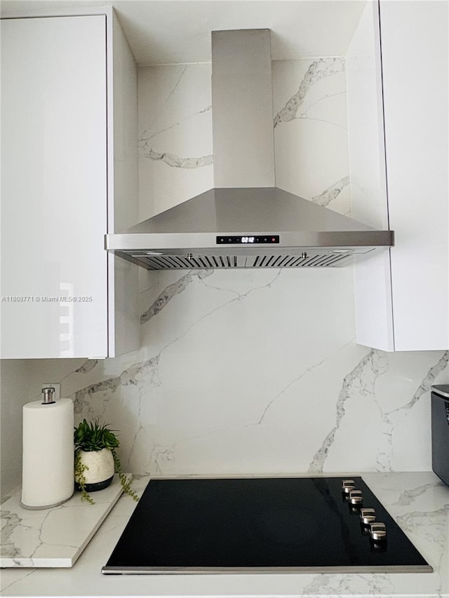 13729 SW 171st Ln, Miami, FL 33177 - kitchen featuring wall chimney range hood, white cabinets, black electric stovetop, light stone countertops, and marble finish floors