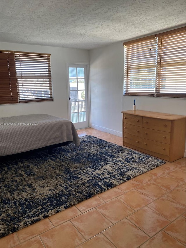 1424 SE 15th St Unit 45, Fort Lauderdale, FL 33316 - bedroom featuring access to exterior, a textured ceiling, and light tile patterned flooring