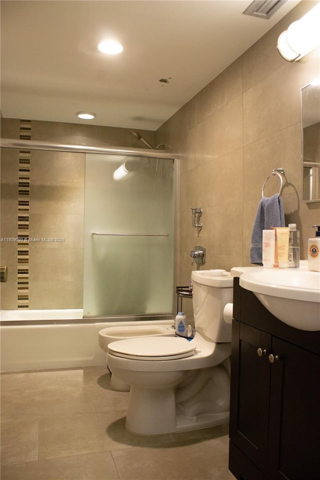 1865 Brickell Ave Unit A2111, Miami, FL 33129 - bathroom with tile walls, toilet, vanity, bath / shower combo with glass door, and tile patterned flooring