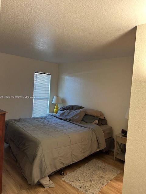 5326 NE 6th Ave Unit E23, Oakland Park, FL 33334 - bedroom featuring wood finished floors and a textured ceiling