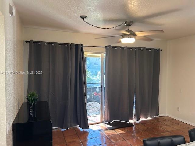 5326 NE 6th Ave Unit E23, Oakland Park, FL 33334 - entrance foyer featuring a ceiling fan, a textured ceiling, tile patterned floors, and baseboards