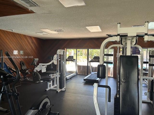 5326 NE 6th Ave Unit E23, Oakland Park, FL 33334 - workout area featuring a textured ceiling and wood walls